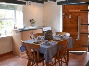 kuchnia ze stołem, krzesłami i zlewem w obiekcie Trekeive Cottage w mieście Saint Cleer