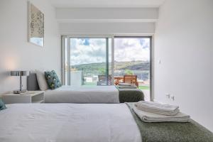 里斯本的住宿－Fabulous Terrace over Monsanto by Innkeeper，白色卧室设有两张床和大窗户