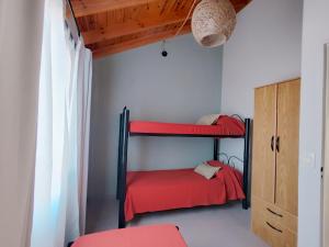 1 dormitorio con 2 literas con sábanas rojas en Andalhue 1 en Playas Doradas