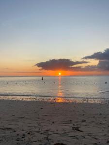 a sunset on the beach with the sun setting at Nivi Cosy Appartment in Flic-en-Flac