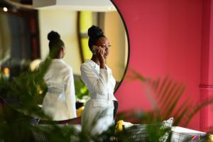 a woman talking on a cell phone in front of a mirror at Next To Apartment Hotel in Pretoria