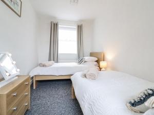 1 dormitorio con 2 camas y ventana en Nantclwyd en Llangollen