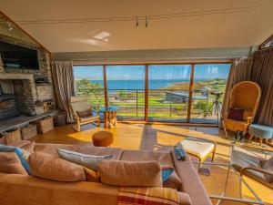 a living room with a couch and a view of the ocean at The Steading in Stromness
