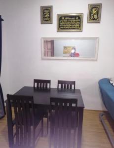a dining room with a table and chairs and a mirror at Sobey Laris Homestay RAZLEEN in Ketereh