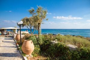 a beach with a large vase next to the ocean at Blue Beach Villas Apartments in Stavros