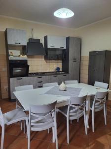 - une cuisine avec une table blanche et des chaises blanches dans l'établissement La casa di Ilenia e Alessia, à Piana di Caiazzo