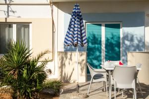 a patio with a table and chairs and an umbrella at Blue Beach Villas Apartments in Stavros