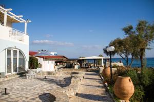a house with a stone walkway next to the ocean at Blue Beach Villas Apartments in Stavros