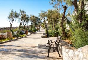 a park bench sitting on a stone walkway at Blue Beach Villas Apartments in Stavros