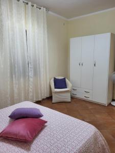 - une chambre dotée d'un lit avec deux oreillers et une chaise dans l'établissement La casa di Ilenia e Alessia, à Piana di Caiazzo