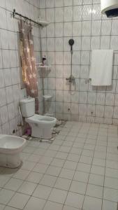 a tiled bathroom with a toilet and a sink at PN Meublés FULL OPTION Odza Dispose d'une voiture et un chauffeur gratuitement de l,aéroport aux appartements pour des réservations minimum de 7 jours in Yaoundé