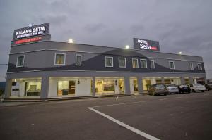 a building with cars parked in a parking lot at Hotel Setia in Kluang