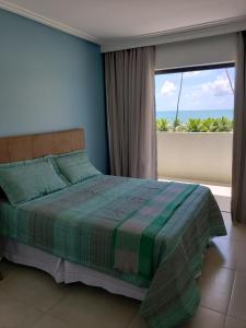 a bedroom with a bed with a view of the ocean at Itacimirim - Duplex Aconchegante, Pé na Areia in Itacimirim