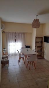 ein Wohnzimmer mit einem Tisch, Stühlen und einem TV in der Unterkunft Excelente departamento en zona céntrica. C/Cochera in Río Cuarto