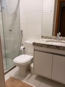 uma casa de banho com um WC, um lavatório e um chuveiro em Itacimirim - Duplex Aconchegante, Pé na Areia em Itacimirim