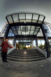 un homme debout devant un bâtiment avec des escaliers dans l'établissement Hotel Lav Vukovar, à Vukovar