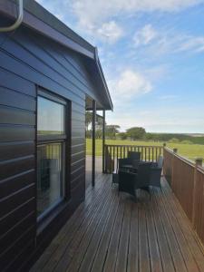 a deck with a table and chairs on a house at Marios Lodge in Padstow