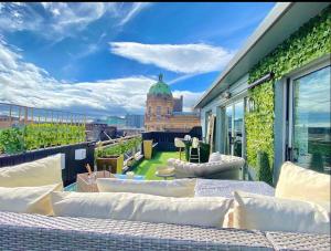 a balcony with couches and a view of a building at Glasgow two bedroom Penthouse in Glasgow