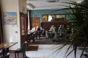 La gente está sentada en las mesas de un restaurante. en Jacksons Restaurant and Accommodation, en Roscommon