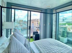a bedroom with a bed and a large window at Glasgow two bedroom Penthouse in Glasgow