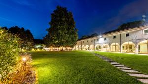 a large building with a green yard at night at Villa I Pini in Malo