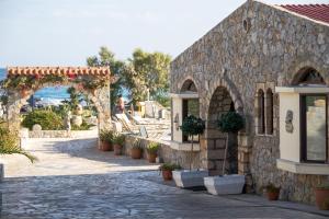 a stone building with an arch and potted plants at Blue Beach Villas Apartments in Stavros