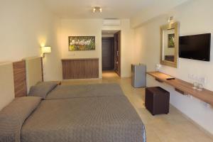 a bedroom with a bed and a flat screen tv at Nelia Gardens in Ayia Napa +15 photos
