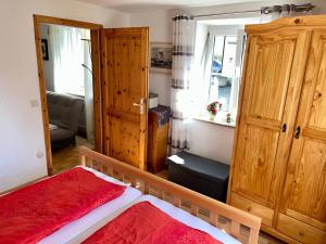 a bedroom with a bed and a wooden cabinet at FeWo HoLiDay ApartMENT Allgäu in Ottobeuren