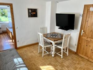 a living room with a table and a television at FeWo HoLiDay ApartMENT Allgäu in Ottobeuren