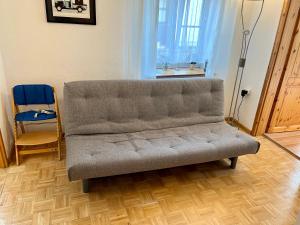 a couch in a living room with a chair and a window at FeWo HoLiDay ApartMENT Allgäu in Ottobeuren