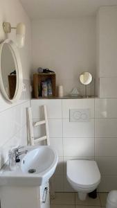a bathroom with a sink and a toilet and a mirror at Gästehaus Bönebüttel-nahe Neumünster Netflix in Bönebüttel
