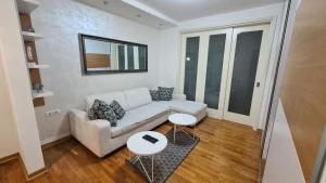 a living room with a white couch and a table at Belville City apartment in Belgrade