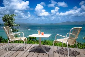 een tafel en stoelen op een terras met uitzicht op de oceaan bij B&B HOTEL Fort-de-France in Fort-de-France