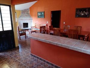 a dining room with a table and chairs and a fireplace at Cabañas Zacatlan Zacapa in San José Ayotla
