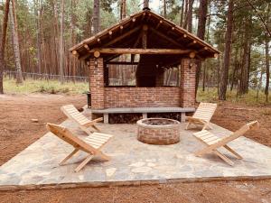 a picnic shelter with two chairs and a fire pit at Cabañas Zacatlan Zacapa in San José Ayotla