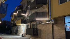 a building with balconies on the side of it at night at White pearl in Veliko Gradište