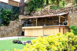 a stone building with a bar in a yard at ~Villa El Riu del Cel~Increíbles vistas al mar in Lloret de Mar