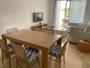 een woonkamer met een houten tafel en stoelen bij Precioso apartamento a pie de playa in Estepona
