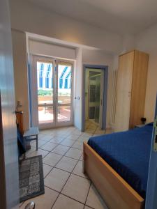 Schlafzimmer mit einem Bett und einer Glasschiebetür in der Unterkunft Le Tre Palme in Ancona