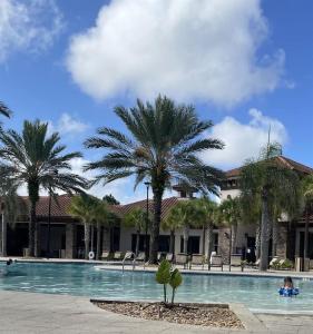 a swimming pool with palm trees in front of a building at 4159 -Private Pool&Spa at Resort-slides in Davenport