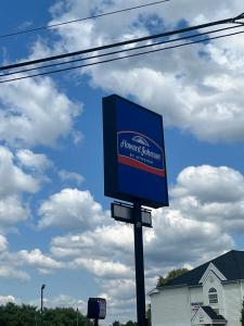 una señal azul en un poste frente a una casa en Howard Johnson by Wyndham Clarksville Tennessee, en Clarksville