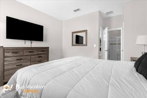 a white bedroom with a large bed and a flat screen tv at 4159 -Private Pool&Spa at Resort-slides in Davenport