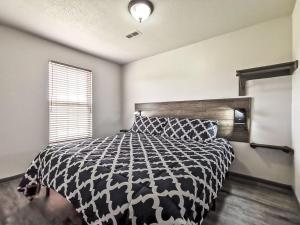 um quarto com uma cama em preto e branco e uma janela em Freestanding 1 Bedroom Cabin 