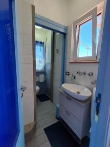 bagno con lavandino, servizi igienici e specchio di Le Tre Palme ad Ancona