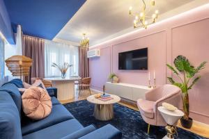 sala de estar con sofá azul y paredes rosas en HOLT - Jules Verne's Imaginarium, en Bucarest