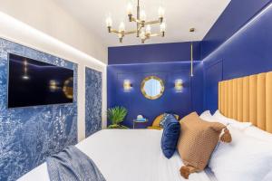 Un dormitorio azul con una cama grande y una lámpara de araña. en HOLT - Jules Verne's Imaginarium, en Bucarest