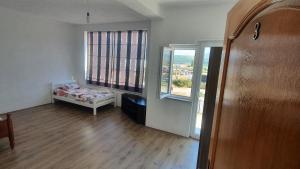 a small room with a bed and two windows at ARBI GUEST House in Kukës