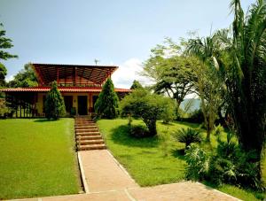 Casa Campestre Villa del Lago في غوادواس: منزل به مسار يؤدي إلى ساحة