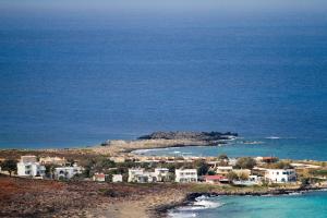 a group of houses on a hill next to the ocean at Blue Beach Villas Apartments in Stavros