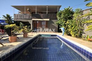 a swimming pool with a peacock in front of a house at GO Hotelaria in Búzios